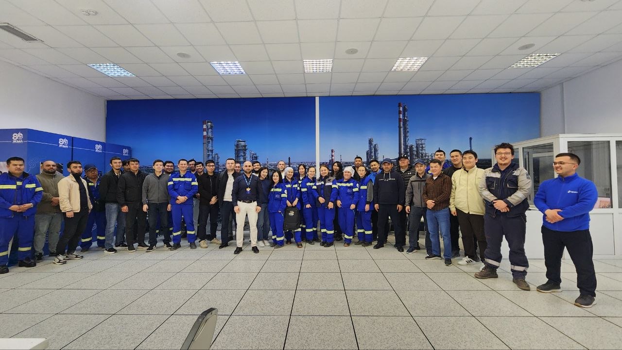 A full cohort of trainees in coveralls at an industrial site with IOSS